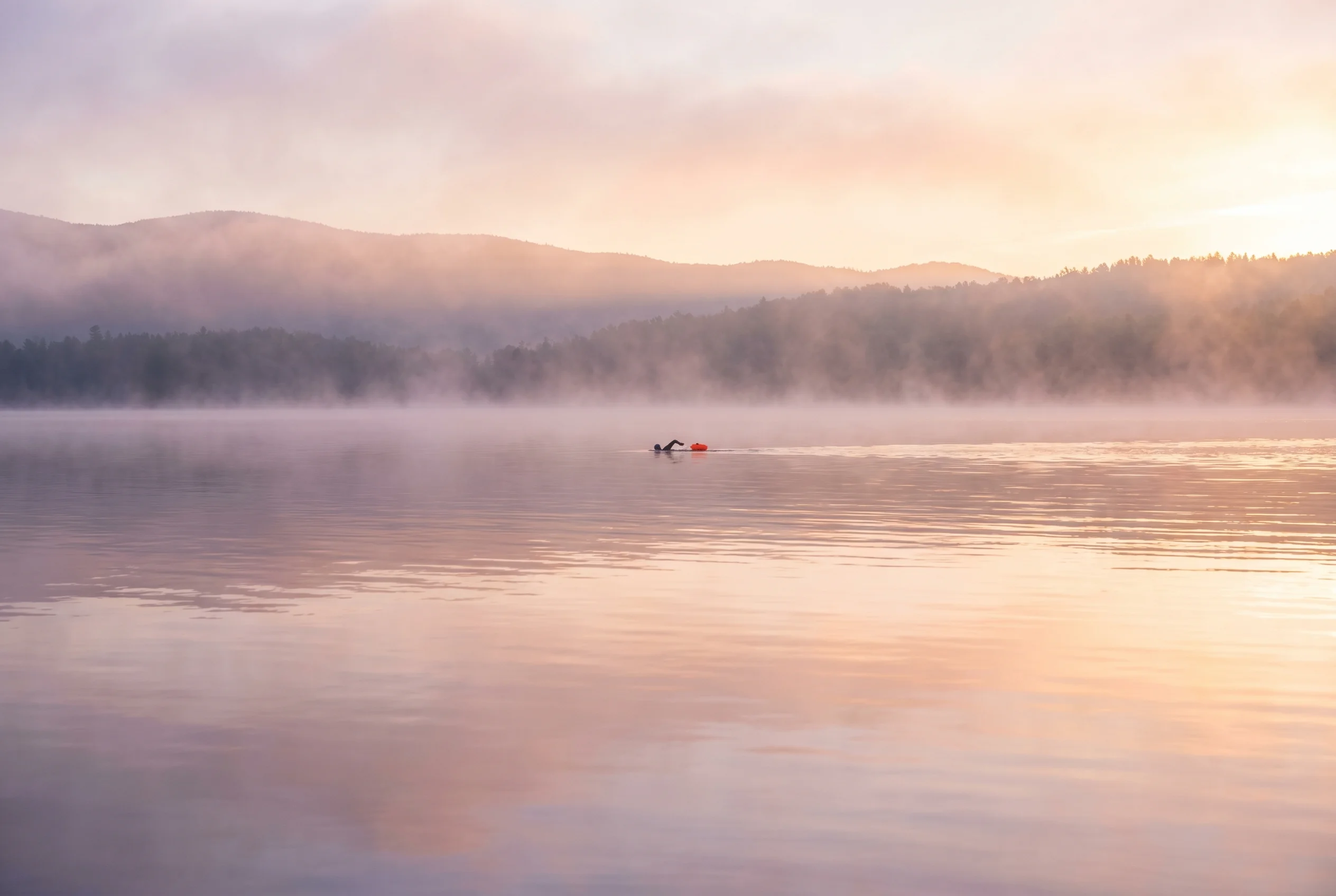 An open-water athlete moving through calm water